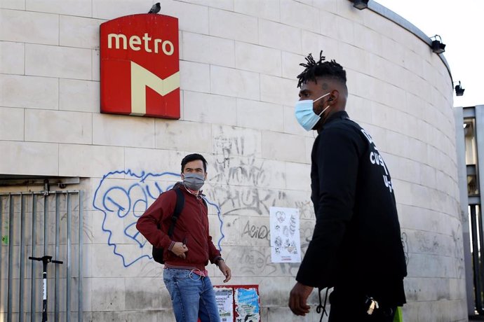 Personas con mascarilla junto a una parada del Metro de Lisboa