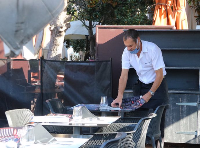 Un cambrer preparant taules en un restaurant de Perpiny aquest 23 d'octubre del 2020. (Horitzontal)