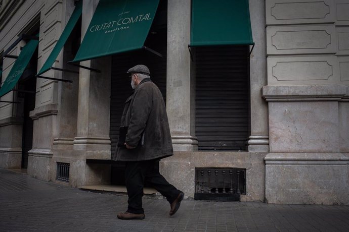 Un hombre pasa junto a un restaurante cerrado durante el cuarto día de la entrada en vigor de las nuevas restricciones en Cataluña, en Barcelona, Cataluña (España) a 20 de octubre de 2020. El pasado viernes 16 de octubre entraron en vigor las nuevas res