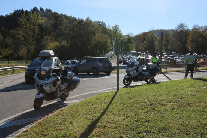 Pla mitj de dos Mossos vigilant l'accés a l'aparcament de Can Serra de la Fageda d'en Jord aquest dissabte 24 d'octubre de 2020. (Horitzontal)