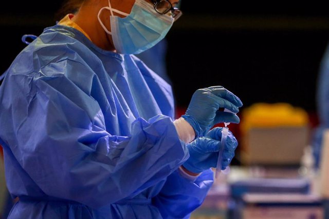 Una trabajadora sanitaria coloca el material utilizado para realizar tests de antígenos en Alcobendas.