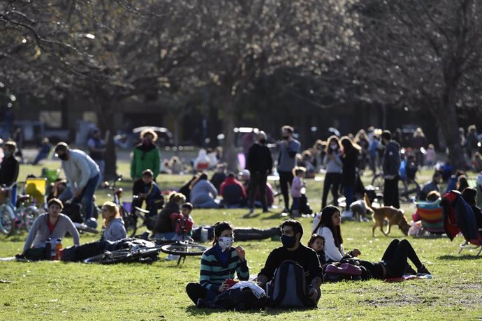 Personas sentadas en un parque de Buenos Aires