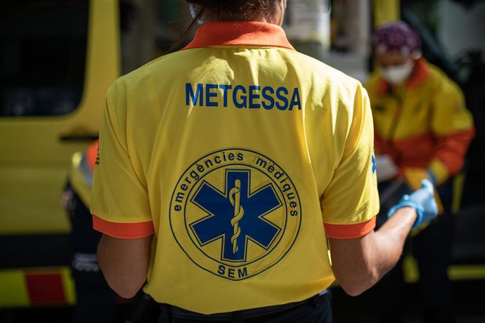 Dos tcnics del Sistema d'Emergncies Mdiques (SEM) de la Generalitat de Catalunya mouen una llitera al costat d'una ambulncia durant un servei i neteja d'EPIs, a Barcelona/Catalunya (Espanya) a 19 d'abril del 2020.