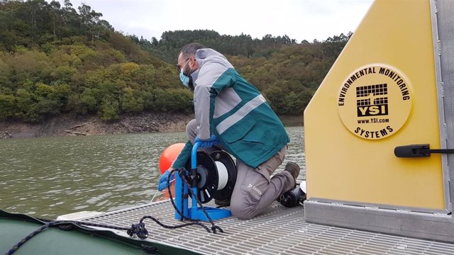 Un técnico toma muestras de agua en el río Eume.