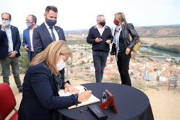 Pla mitj de la consellera de Cultura, ngels Ponsa, signant el llibre d'honor d'Ascó des del castell. Foto del 25 d'octubre del 2020 (vertical).