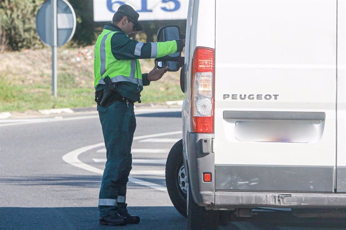 Un agente de la Guardia Civil de Tráfico pide la documentación a una furgoneta durante la campaña especial de la DGT de vigilancia y control de furgonetas, en el Km 0,1 de la M-511, en Madrid, a 28 de octubre de 2019.