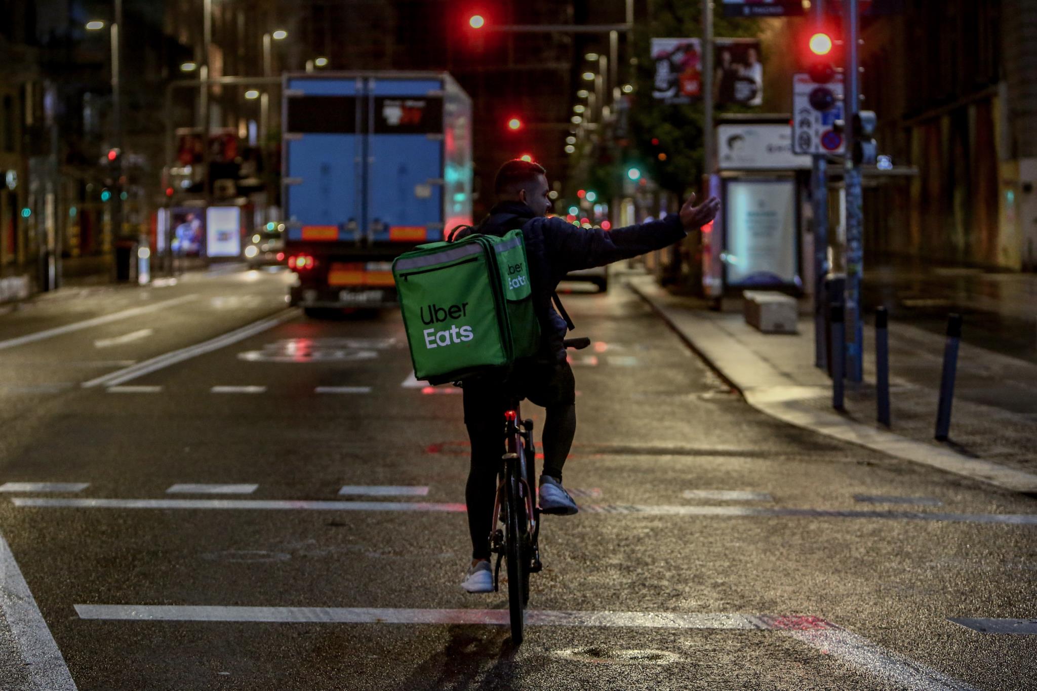 Un rider de Uber Eats circula durante la primera noche de toque de queda en Madrid