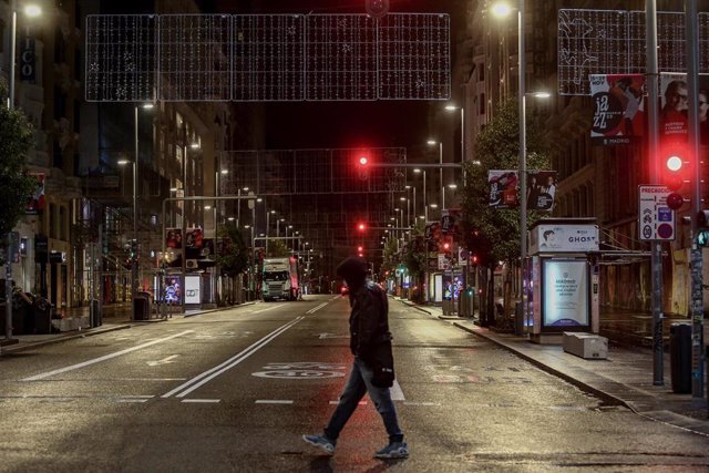 Un chico cruza una calle del centro de Madrid durante la primera noche de toque de queda en Madrid