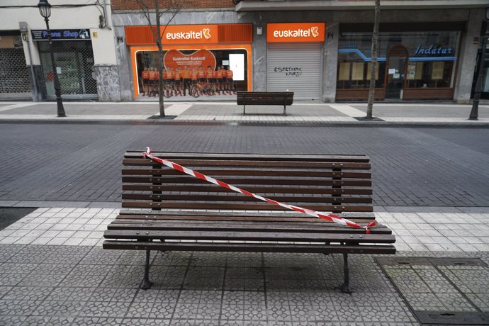 Un banco precintado en una calle de Bilbao que despierta totalmente vacía durante la cuarentena por covid a 31 de marzo de 2020.