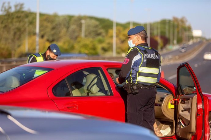 Varios agentes de policía municipal le piden la documentación al conductor de un vehículo durante un control efectuado en la Carretera de Castilla sentido salida, a la altura del Club de Campo, en Madrid, (España), a 10 de octubre de 2020. Este control,