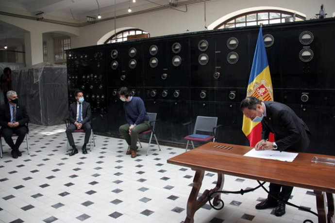Pla obert del cap de govern d'Andorra, Xavier Espot, signant un pacte sobre la negociació de l'acord d'associació amb la UE amb la resta de grups parlamentaris i on es veu, al fons, alguns dels seus representants, el 26 d'octubre de 2020 (Horitzontal).