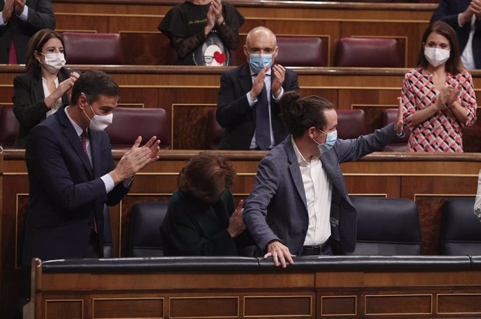 El presidente del Gobierno, Pedro Sánchez (i), acompañado de otros miembros del partido aplauden al vicepresidente segundo del Gobierno, Pablo Iglesias (c), tras su intervención en la segunda sesión del pleno en el que se debate la moción de censura pla
