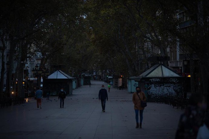 Varias personas caminan por el centro de Barcelona en el primer amanecer después del toque de queda en la ciudad.