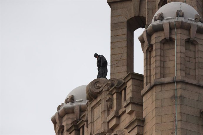 15 October 2020, England, Liverpool: A stuntman secured by a safety wire, stands on top of The Royal Liver Building in Liverpool during filming of The Batman. Photo: Peter Byrne/PA Wire/dpa