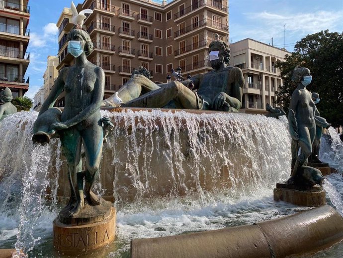 Esculturas de la fuente de la Plaza de la Virgen de Valncia con mascarillas para concienciar a la ciudadanía sobre la necesidad de su uso frente de la Covid-19.