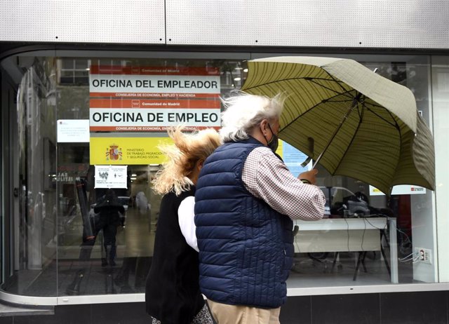 Una pareja pasa al lado de una Oficina de Empleo en Madrid (España)