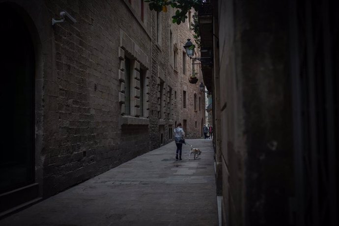 Una persona pasea por una calle del Barrio Gótico una semana después de la entrada de las nuevas restricciones en Cataluña, en Barcelona, Cataluña (España) a 23 de octubre de 2020. 