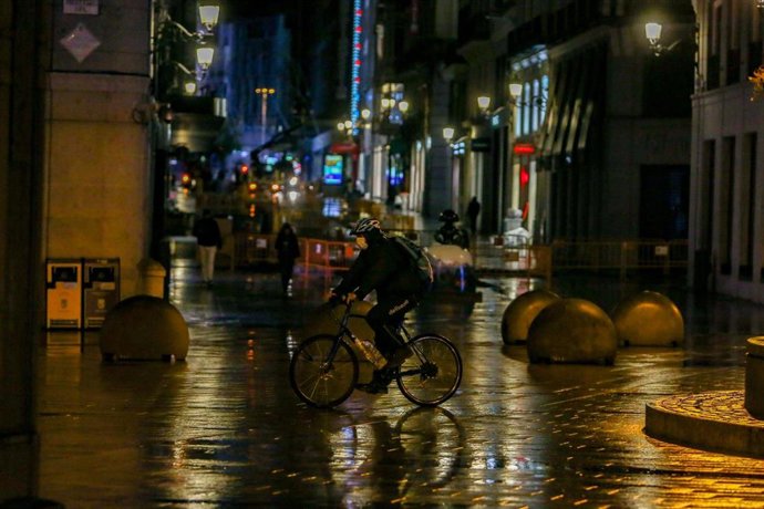 Un rider circula durante la primera noche de toque de queda en Madrid (España) 