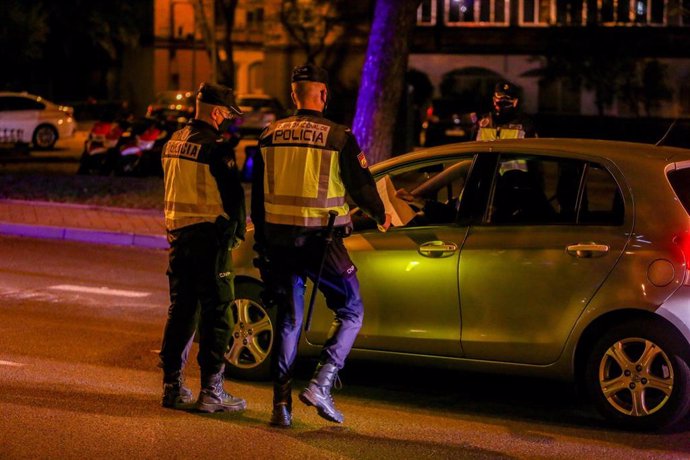 Dos policías nacionales paran a un coche en un control en Madrid