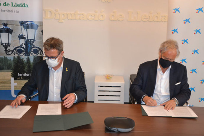 Pla mitj del president de la Diputació de Lleida, Joan Talarn, i el director de Banca d'Institucions de CaixaBank i director territorial de Catalunya, Joaquim Maci, signant el conveni de collaboració, el 27 d'octubre del 2020. (Horitzontal)