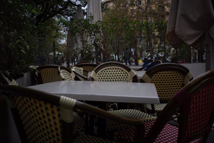 Sillas y mesas de la terraza de un bar cerrado durante el cuarto día de la entrada en vigor de las nuevas restricciones en Cataluña, en Barcelona, Cataluña (España) a 20 de octubre de 2020.
