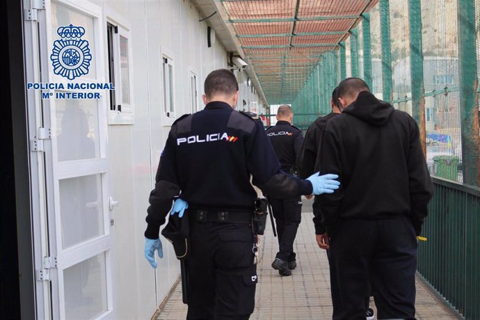 Un agente de Policía Nacional acompaña a un inmigrante en el CATE de Almería