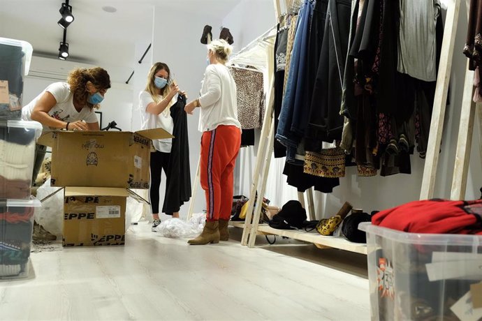 Empleadas de una tienda de ropa en Palma se preparan para abrir al público.