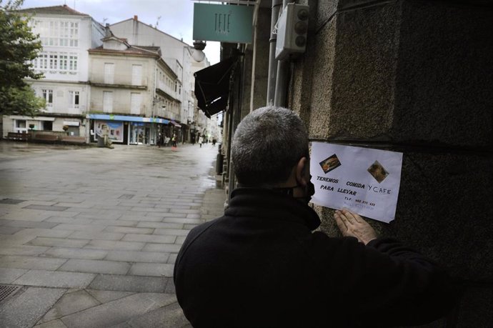 Cartel en el exterior del Mesón "Los Portales" en la Plaza Mayor de O Carballiño, en el que se lee que sirven comida y café para llevar.