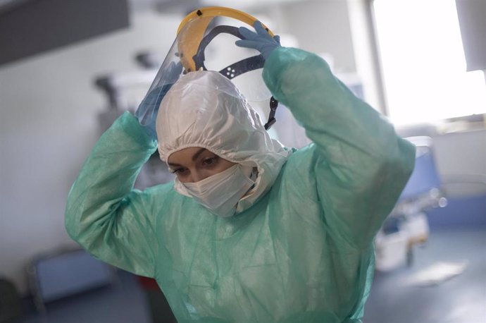 Una sanitaria se retira la pantalla protectora en la Unidad de Cuidados Intensivos (UCI) dedicada a enfermos de coronavirus del Hospital Universitario Ramón y Cajal