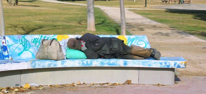 Persona sin hogar en un banco, en una imagen de archivo.