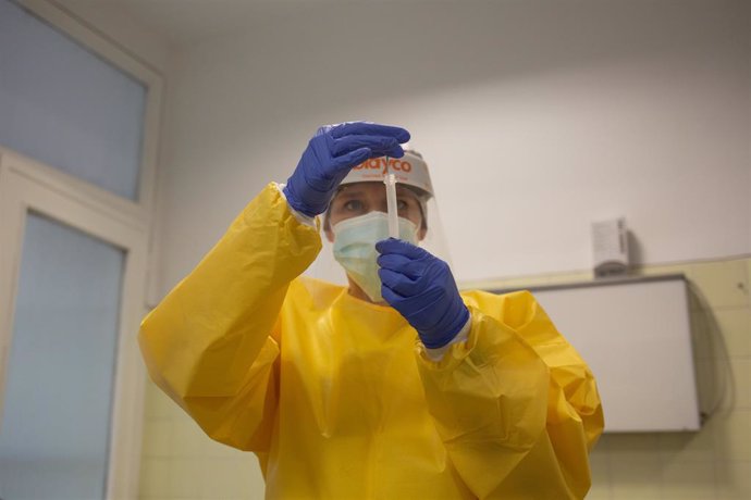 Una sanitria sosté un dels test rpids d'antígens de detecció de coronavirus 