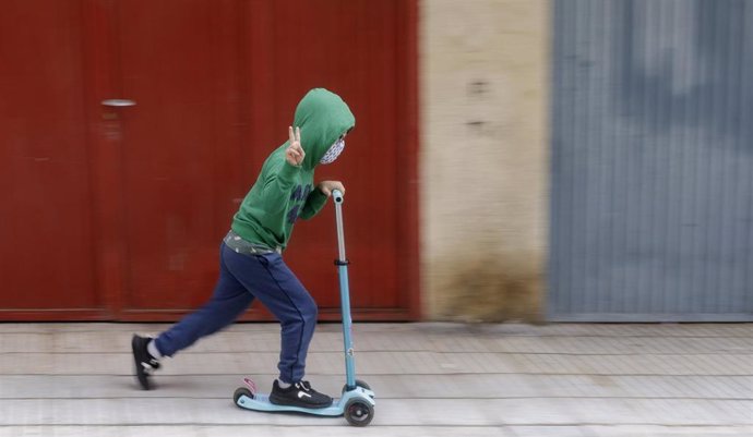 Un niño monta en patinete el primer día en el que los menores de 14 años pueden 
