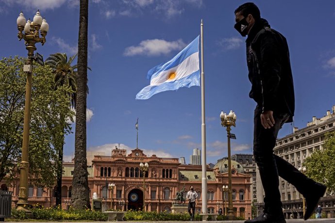 05 October 2020, Argentina, Buenos Aires: A man wearing a face mask walks down a