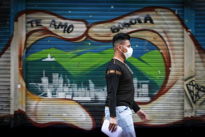 10 March 2020, Colombia, Bogota: A man wearing a surgical mask walks through the