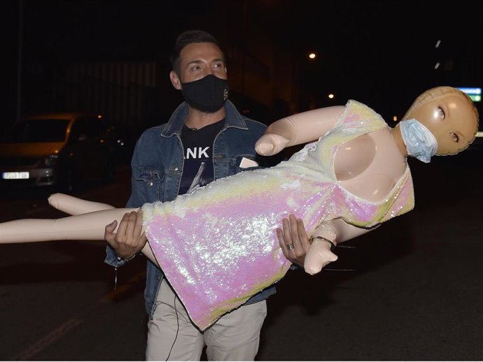 Antonio David Flores, esposado a una muñeca hinchable, llega al hotel en el que se hospeda