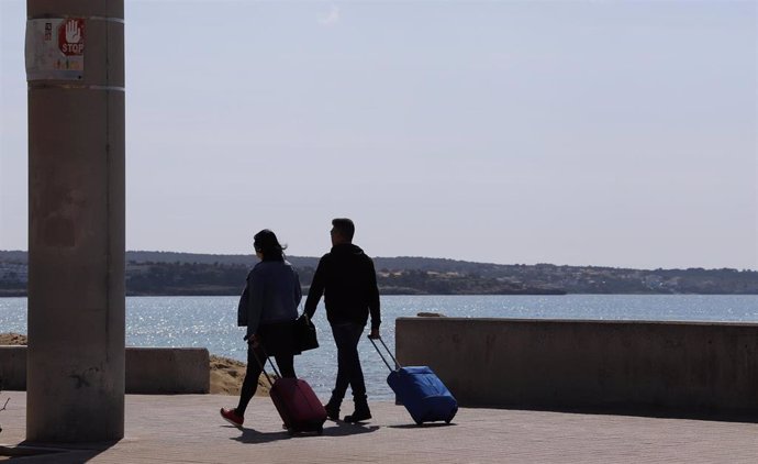 Turistas con maletas en el Arenal.