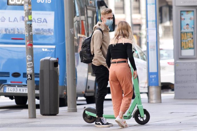 Dos turistas pasean por una calle de Madrid.