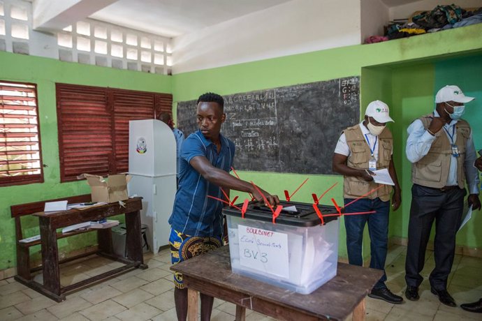 18 October 2020, Guinea, Conakry: A man casts his vote inside a polling station 