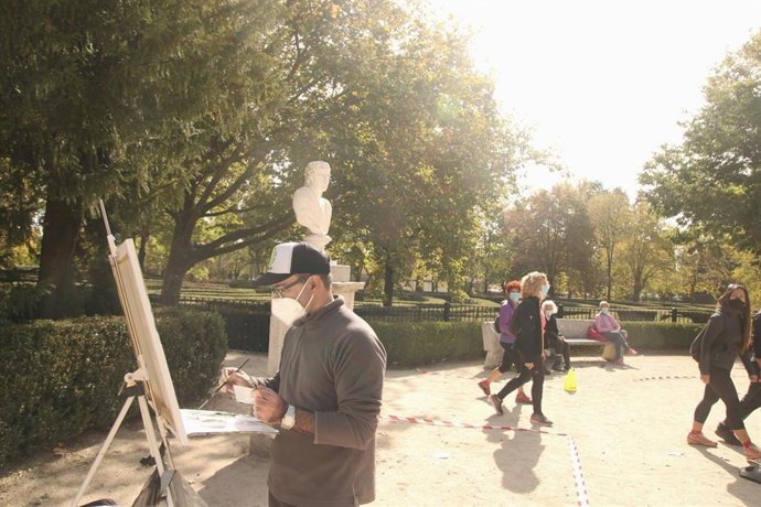 Un hombre pinta un cuadro durante su participación en el XVI Certamen Nacional de Pintura Rápida en el Parque de El Capricho, en Madrid (España) a 17 de octubre de 2020. Este año, la temática del concurso artístico gira en torno al otoño en el parque, s