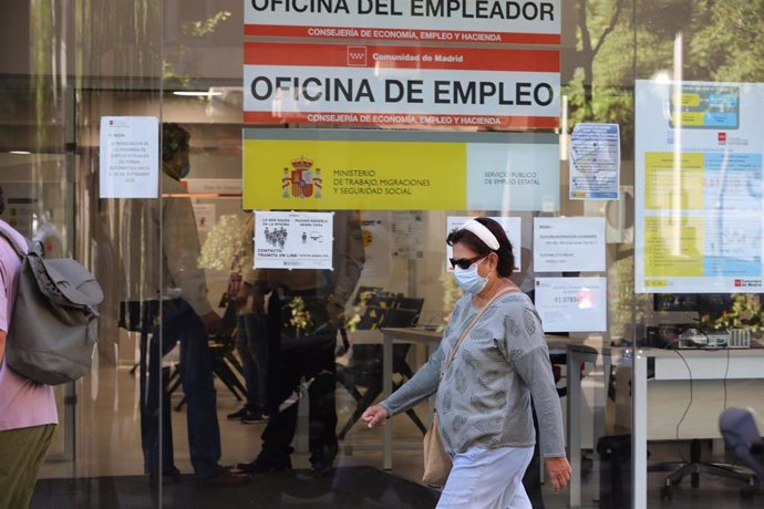 Una mujer con mascarilla pasa por una oficina de empleo de Madrid