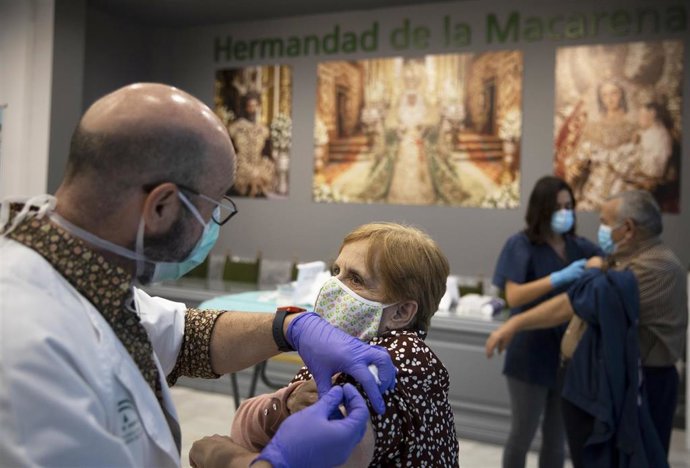 Dos personas se vacunan en la Casa de Hermandad de la Macarena, durante la administración de vacunas contra la gripe a personas mayores de 65 años, foto de archivo