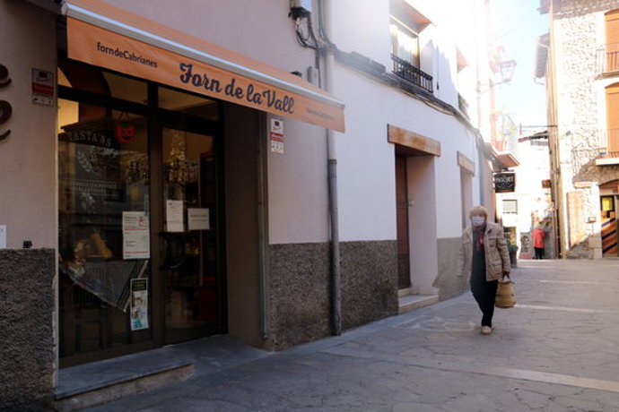 Una dona passa per davant d'un forn de pa a Sant Lloren de Morunys. 30 d'octubre de 2020. (Horitzontal)
