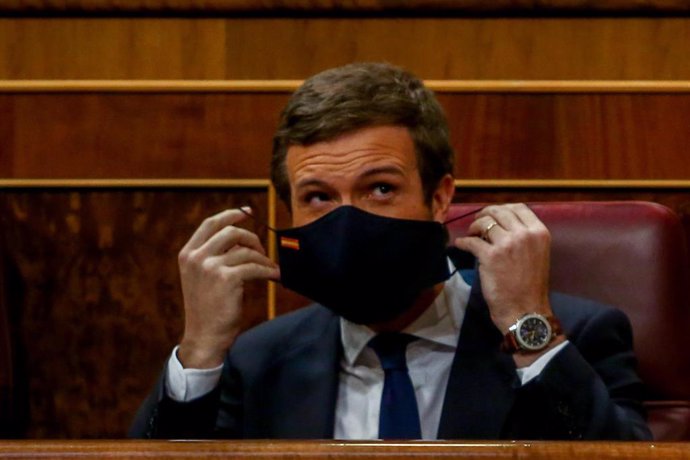 El líder del PP, Pablo Casado, se coloca la mascarilla durante una sesión plenaria en la que, tras la petición del  Gobierno, el Pleno ha aprobado la prórroga hasta el 9 de mayo de 2021 del estado de alarma decretado por la crisis del Covid-19, en Madri