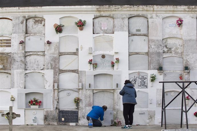 Dos personas limpian uno de los nichos del Cementerio parroquial de Luarca capital del concejo de Valdés, Principado de Asturias (España), a 27 de octubre de 2020.  El 1 de noviembre, Día de Todos los Santos, los cementerios son visita obligada para muc
