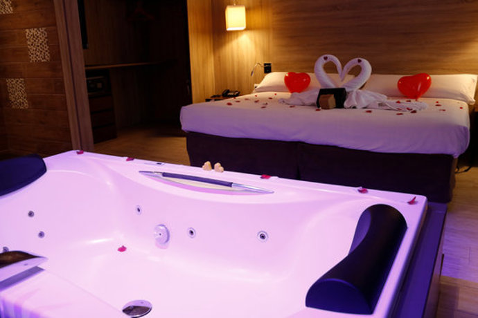 Pla general d'una habitació romntica, amb una gran banyera hidromassatge, que s'ofereix a l'hotel Flix de Valls. Imatge del 30 d'octubre de 2020 (Horitzontal)