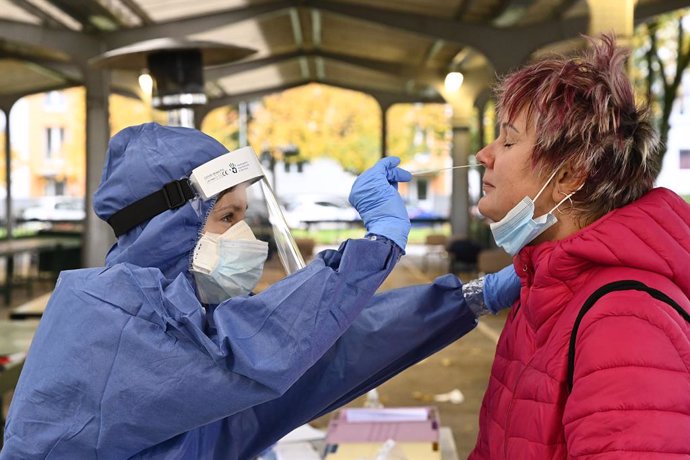 31 October 2020, Slovakia, Trencin: A health worker takes a swab from a woman for coronavirus (COVID-19) test during the nationwide testing campaign. Photo: Radovan Stoklasa/TASR/dpa