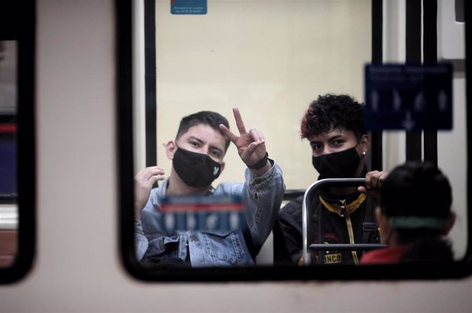 Dos jóvenes viajan en metro 