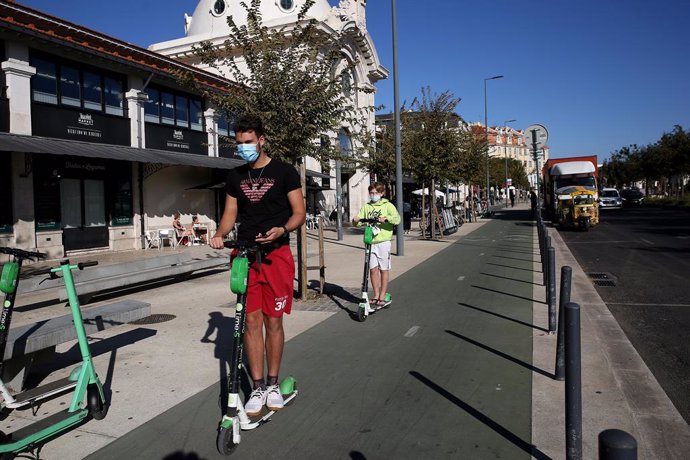 15 October 2020, Portugal, Lisabon: Two boys wearing face masks ride an electric scooter as Portugal declared a nationwide disaster on 14 October due to a sharp rise in coronavirus infections. Photo: Pedro Fiuza/ZUMA Wire/dpa