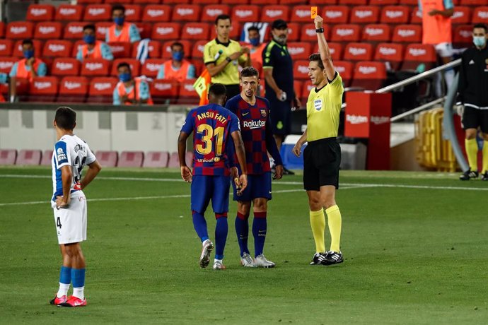 BARCELONA, SPAIN - JULY 08: the referee Jose Luis Munuera Montero showing yellow card to 31 Ansu Fati of FC Barcelona during the Spanish League, La Liga, football match played between FC Barcelona and RCD Espanyol at Camp Nou stadium on July 08, 2020 in