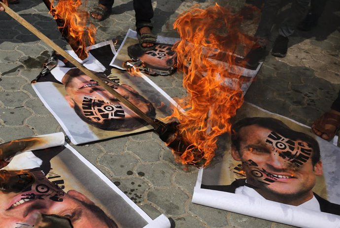 30 October 2020, Bangladesh, Dhaka: Bangladeshi Muslim protesters burn pictures of French President Emmanuel Macron during a demonstration against his comments on Islam's prophet Muhammad cartoons. Photo: Ashraf Amra/APA Images via ZUMA Wire/dpa